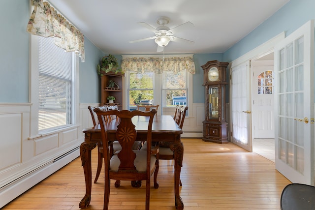 dining space with light hardwood / wood-style floors, baseboard heating, and ceiling fan