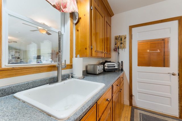 interior space featuring ceiling fan, wood-type flooring, and sink