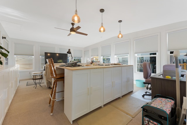 kitchen featuring white cabinetry, light carpet, ceiling fan, lofted ceiling, and pendant lighting