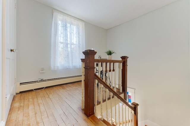 stairs featuring a baseboard radiator and wood-type flooring