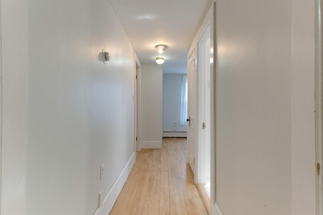 hall featuring a baseboard radiator and light hardwood / wood-style flooring