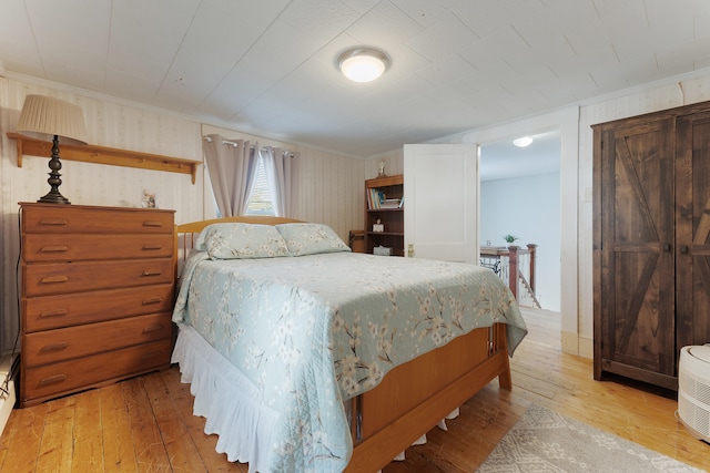 bedroom featuring crown molding and light wood-type flooring