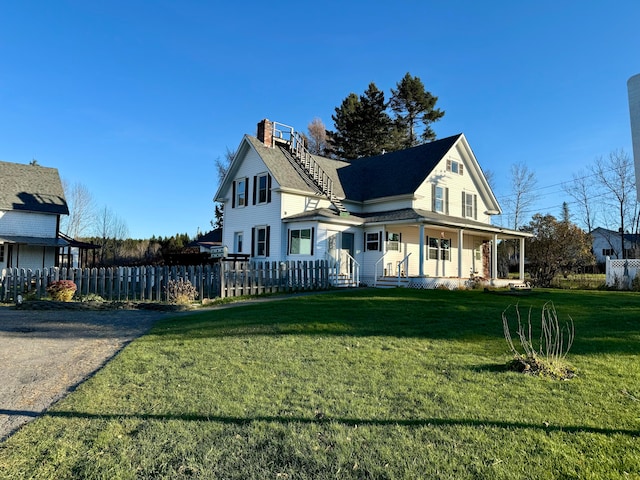 view of side of property featuring a yard and a porch