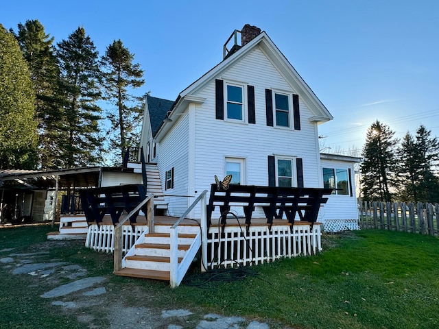 back of property with a wooden deck and a yard