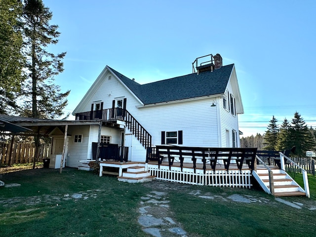 back of house featuring a wooden deck and a yard