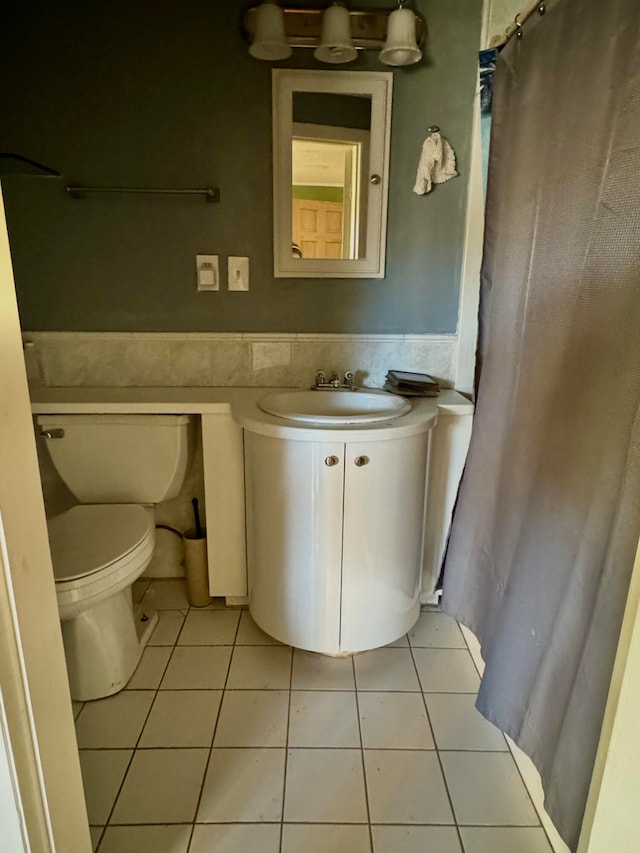 bathroom with vanity, toilet, tile patterned floors, and curtained shower