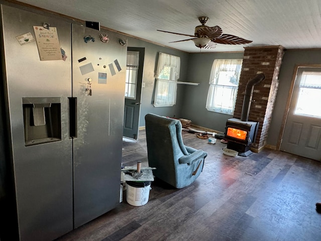 interior space with ornamental molding, hardwood / wood-style flooring, a wood stove, and ceiling fan