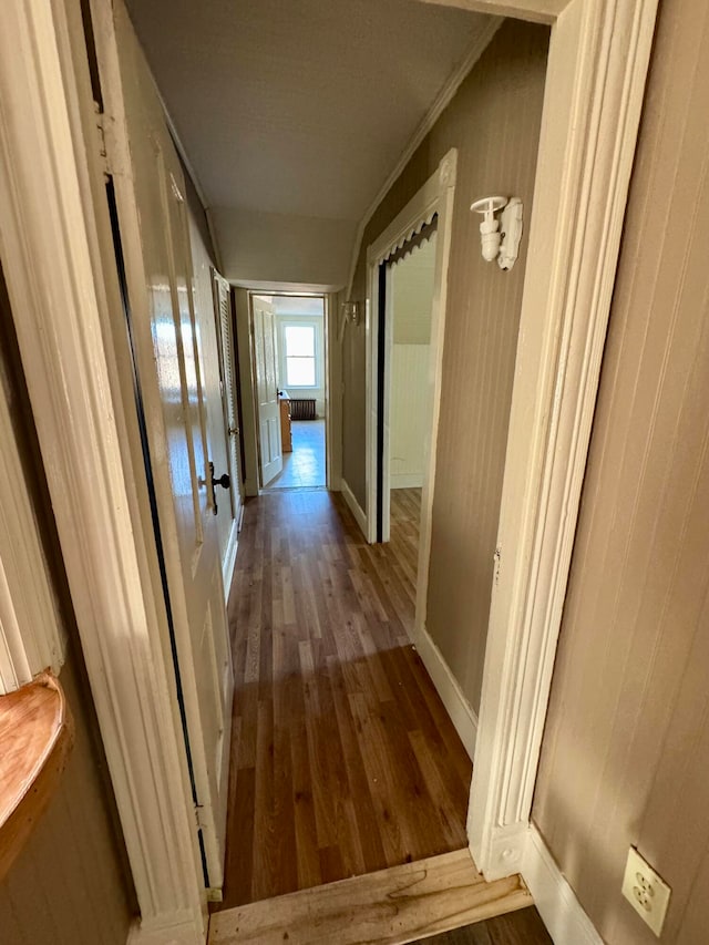 corridor with ornamental molding and dark hardwood / wood-style flooring