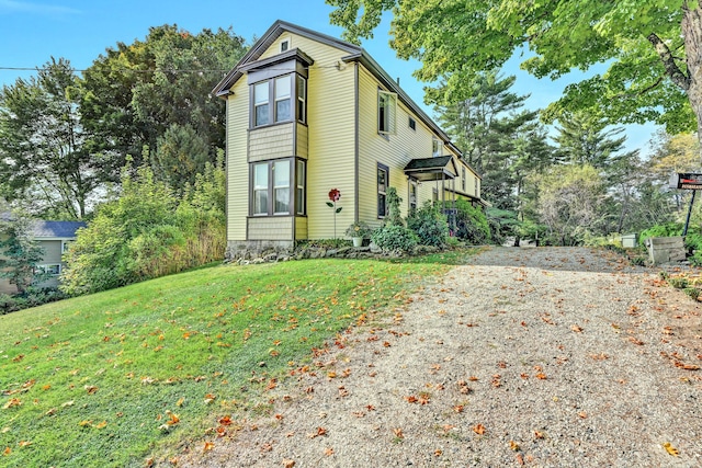 view of front of property featuring gravel driveway and a front yard