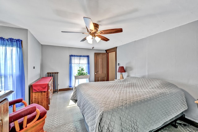 bedroom featuring radiator heating unit, ceiling fan, and baseboards