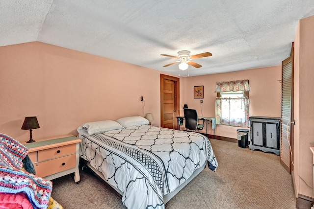 bedroom featuring carpet floors, a textured ceiling, a desk, a ceiling fan, and lofted ceiling