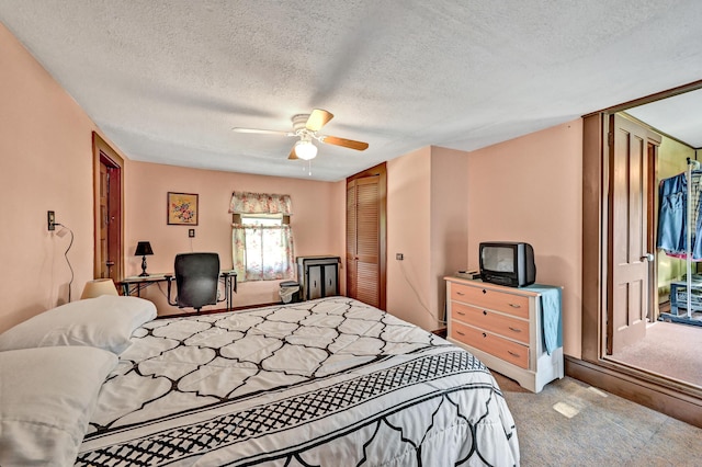 carpeted bedroom featuring a textured ceiling, a closet, a ceiling fan, and an office area