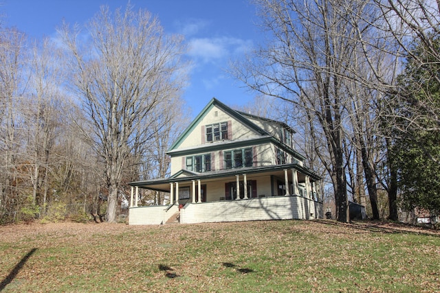 farmhouse featuring covered porch and a front lawn