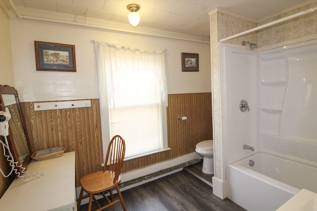 bathroom with toilet, wooden walls, wood-type flooring, and tub / shower combination