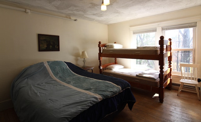 bedroom with hardwood / wood-style floors and a textured ceiling