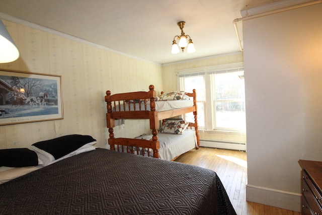 bedroom featuring baseboard heating, crown molding, wood-type flooring, and a chandelier