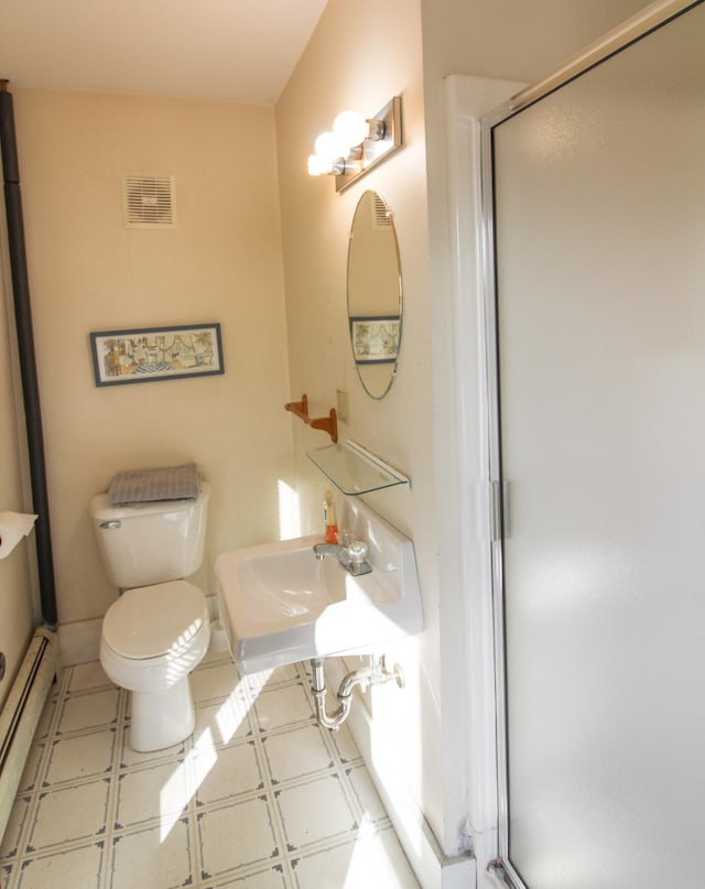 bathroom featuring sink, toilet, a baseboard heating unit, and an enclosed shower