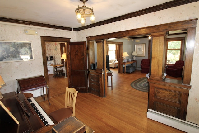 dining space with ornamental molding, decorative columns, wood-type flooring, and a chandelier