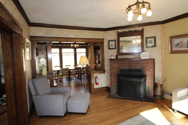 living room with a baseboard radiator, wood-type flooring, ornamental molding, a fireplace, and a notable chandelier