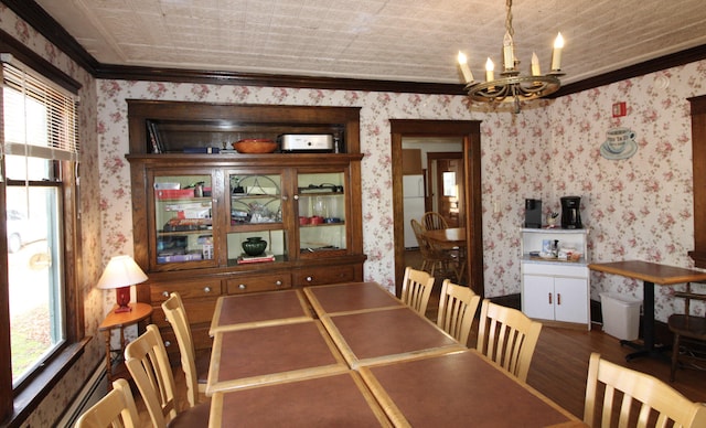 dining room with ornamental molding, a chandelier, and hardwood / wood-style flooring