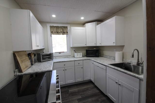 kitchen with sink, white dishwasher, dark hardwood / wood-style flooring, white cabinets, and a drop ceiling