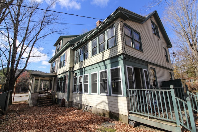 view of side of home featuring a wooden deck and a sunroom