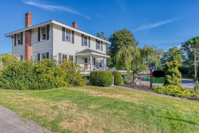 view of front of house featuring covered porch and a front lawn