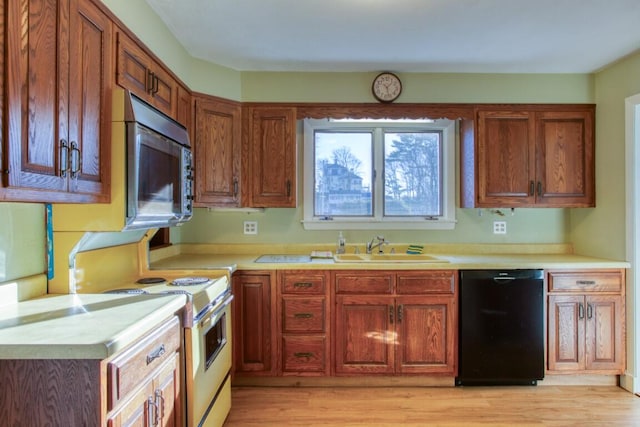 kitchen featuring black dishwasher, sink, white range with electric cooktop, and light hardwood / wood-style floors