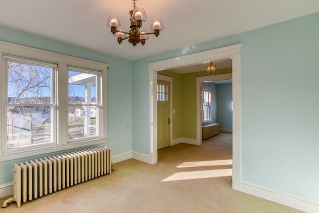 carpeted empty room with an inviting chandelier and radiator