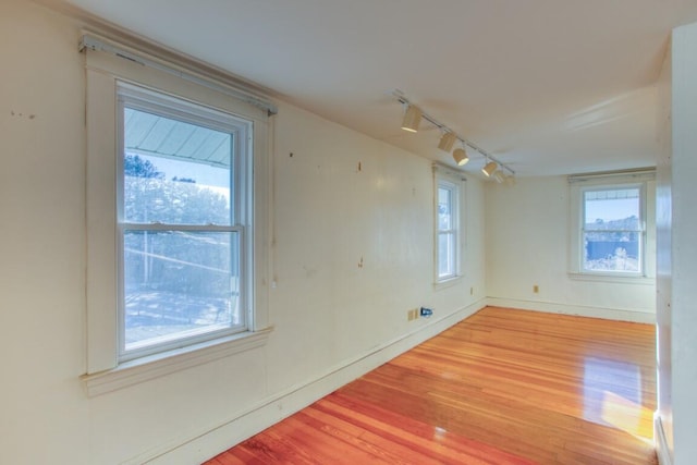 spare room with track lighting and hardwood / wood-style floors