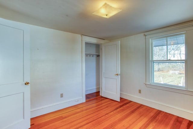 unfurnished bedroom with a closet and light wood-type flooring