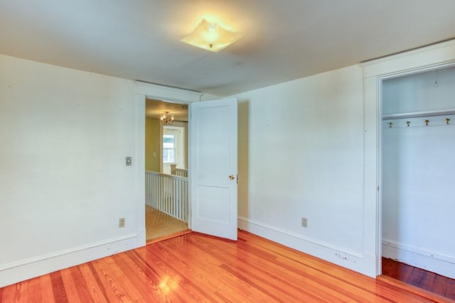 unfurnished bedroom with light hardwood / wood-style flooring and a closet