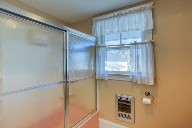 bathroom featuring heating unit and an enclosed shower