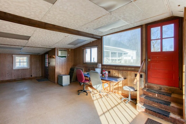 basement with wood walls and a wall mounted AC