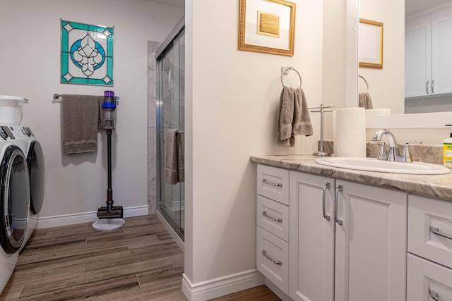 bathroom featuring vanity, washer and dryer, wood-type flooring, and walk in shower