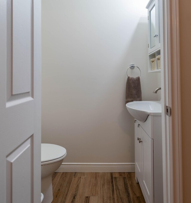 bathroom with vanity, toilet, and hardwood / wood-style floors