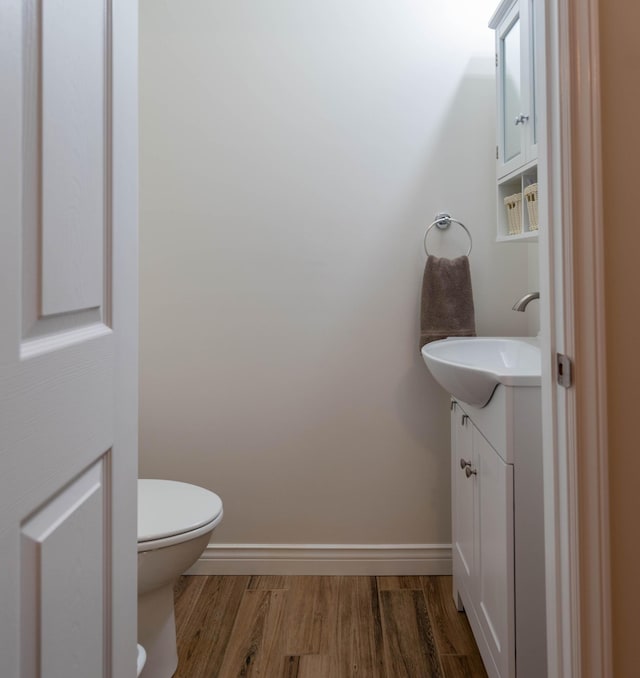 320 19th Ave Unit 101, Madawaska, ME 04756 - half bathroom with vanity, wood finished floors, toilet, and baseboards