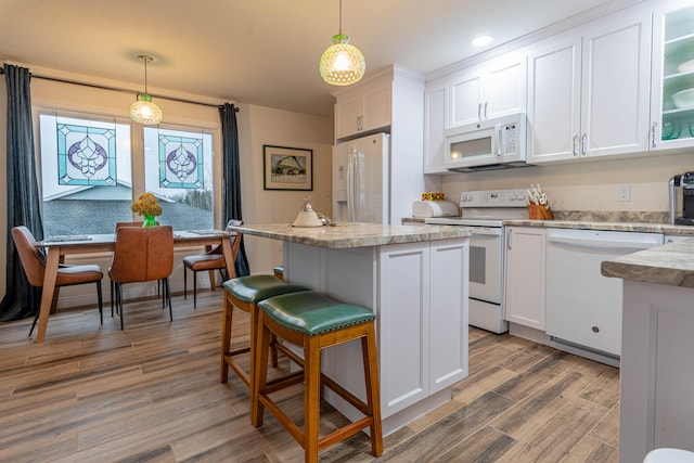 kitchen with white cabinetry, hanging light fixtures, and white appliances