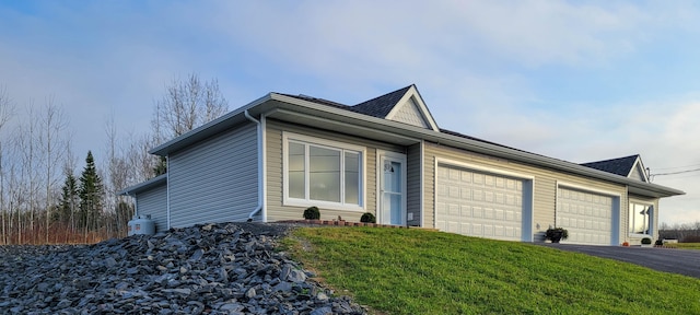 ranch-style home featuring a front lawn and a garage