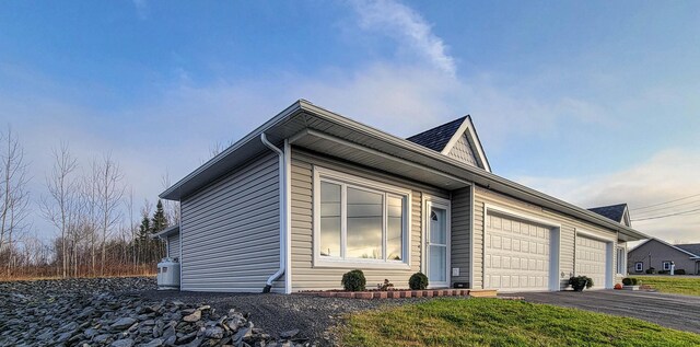 320 19th Ave Unit 101, Madawaska, ME 04756 - view of side of property with a garage and asphalt driveway