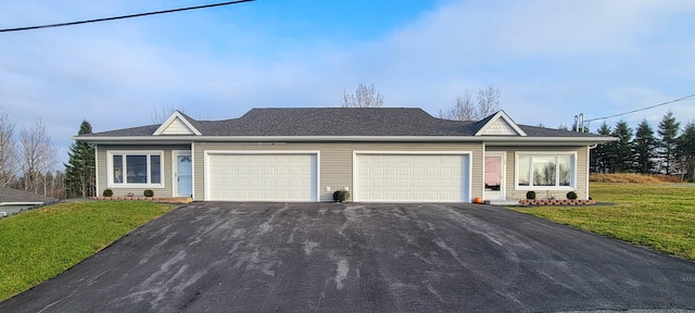 ranch-style house with a garage and a front lawn