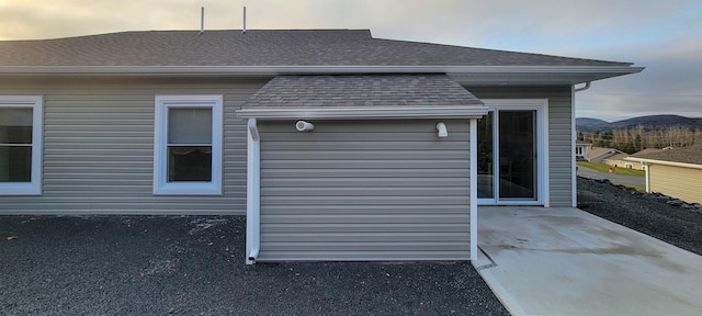 property exterior at dusk featuring a patio