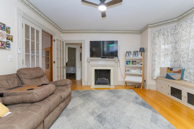 living room featuring ceiling fan, ornamental molding, and hardwood / wood-style floors