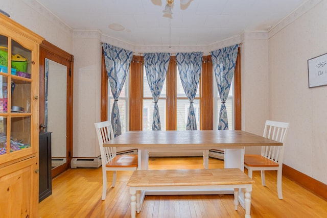 dining space featuring crown molding and light hardwood / wood-style flooring