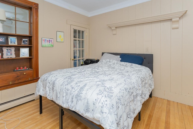 bedroom featuring baseboard heating, ornamental molding, and wood-type flooring