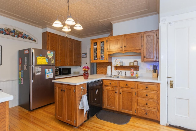 kitchen with black appliances, ornamental molding, light wood-type flooring, and hanging light fixtures