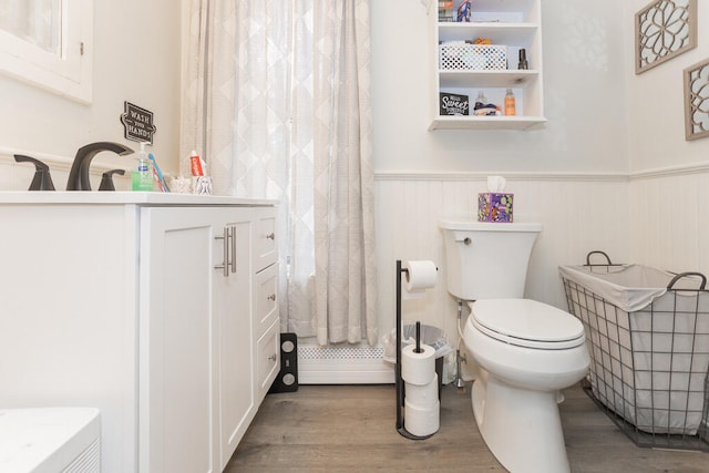 bathroom with vanity, toilet, wood-type flooring, and baseboard heating