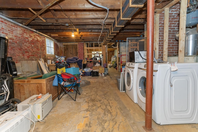 basement with brick wall and independent washer and dryer