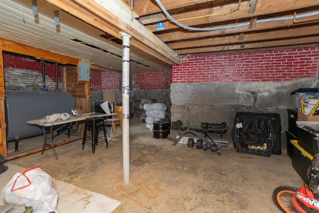 basement featuring brick wall