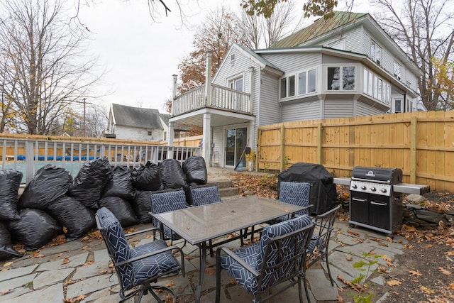 view of patio featuring a grill, a balcony, and a swimming pool